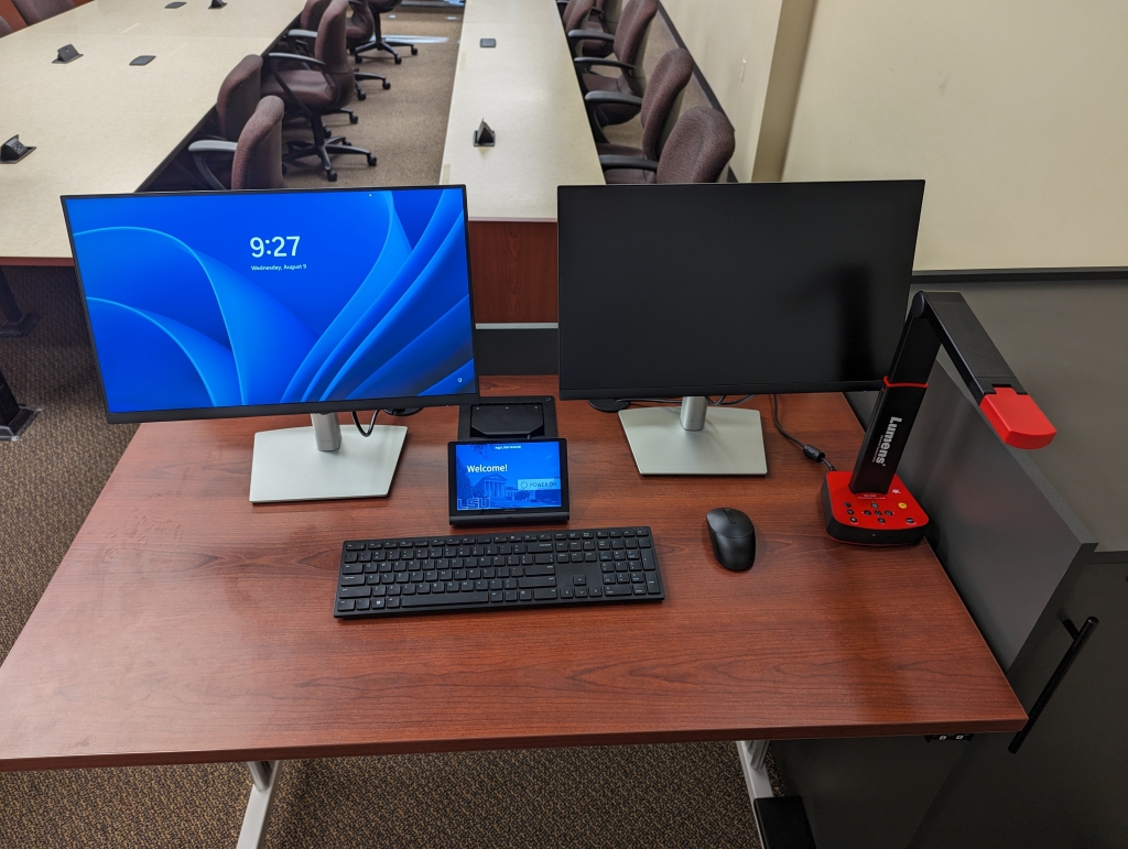 Classroom lectern surface with two monitors, touch panel, wireless keyboard, wireless mouse, and document camera.