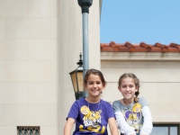 Two children pose for a photo on the front steps of the LSU Law Center
