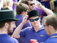 Three male students wear black hats and talk
