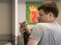 A male student holds a cat