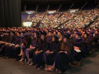 A group of students wearing graduation attire are seated