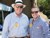 Two males wearing LSU attire smile for a photo