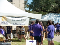 People wearing purple and gold attire talk to each other