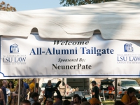 A banner that reads "Welcome All-Alumni Tailgate" hangs from a tent