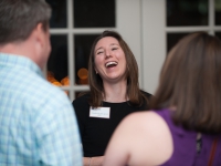 A woman laughs as she talks to a man and a woman