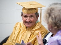 A man wearing a gold robe smiles for a photo