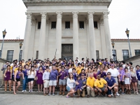 A group of students pose for a photo with the LSU Law Center in the background