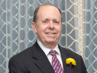 A man wearing a suit and tie poses for a photo