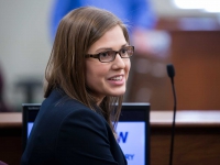 A female student smiles as she sits in the witness stand