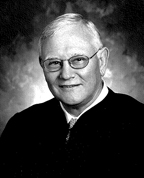 Black and white headshot photo of a man with glasses