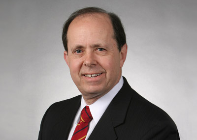 A headshot photo of a man in a suit and tie