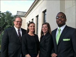 Two male and two female students pose for a photo outside the LSU Law Center