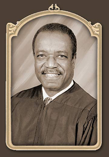 A headshot photo of a man wearing a judicial robe