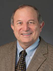 A headhsot photo of a man wearing a suit and tie