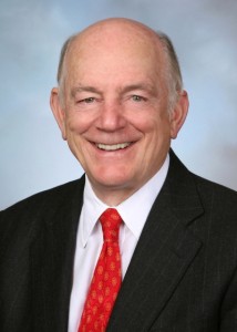 A headshot photo of a man wearing a suit and tie