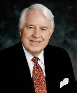 A photo headshot of a man wearing a suit and tie