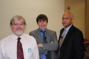 Three professors pose together for a photo in an LSU Law classroom