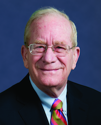 A headshot photo of a man wearing a suit and tie