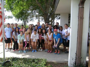 A group of students pose for a photo outside a school