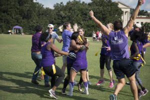 Students hug and celebrate with trees and the LSU Law Center in the background