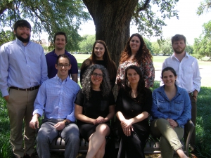 A group photo of nine people under an oak tree