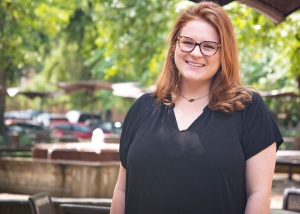 A female student stands in front of the plaza of the LSU Law Center