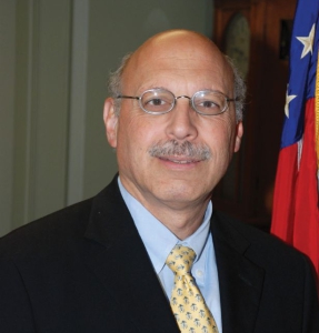 Judge Jay Zainey smiling in front of the U.S. Flag.