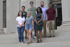 Gabrielle Cox (from left to right), John Arboleda, Andrea Houghtaling, John Clements, Patrika Marschall, Jared Blackburn, and Broxton Lance Harvey pose on the steps of the Old Law Building one week after celebrating their commencement on May 20. 