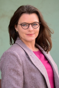 A picture of a woman wearing glasses smiling. 