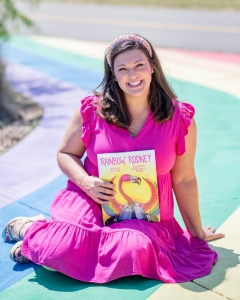 New Orleans real estate attorney and LSU Law Class of 2012 alumna Laura Cotaya Carroll poses with a copy of her new debut children’s book, “Rainbow Rodney.”