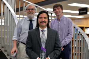 LSU Law Class of 2024 graduate Alvaro de la Cruz-Correa, center, poses with the Ginger Berrigan Worker Bee Award from the Public Interest Law Society at LSU Law, along with PILS Faculty Advisor John Devlin, left, and 2023-24 PILS President William “Grey” Fitzgerald.